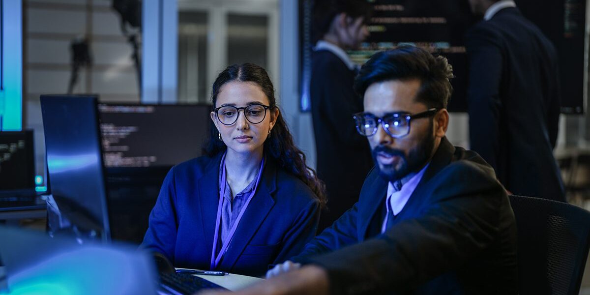 A diverse team of AI developers shares a successful moment in th IT Security Houston